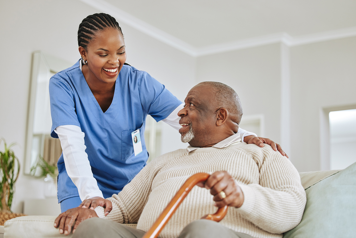 Caregiver nurse with senior man on a couch, retirement or help with healthcare or walking stick.