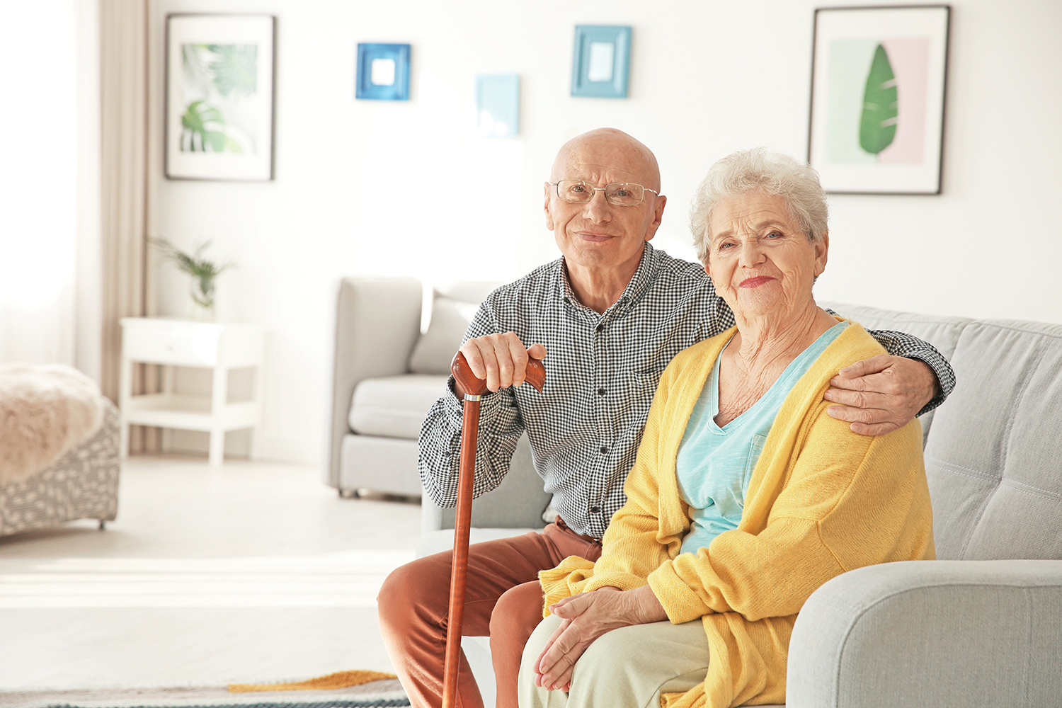 Older couple sitting together on a couch, smiling