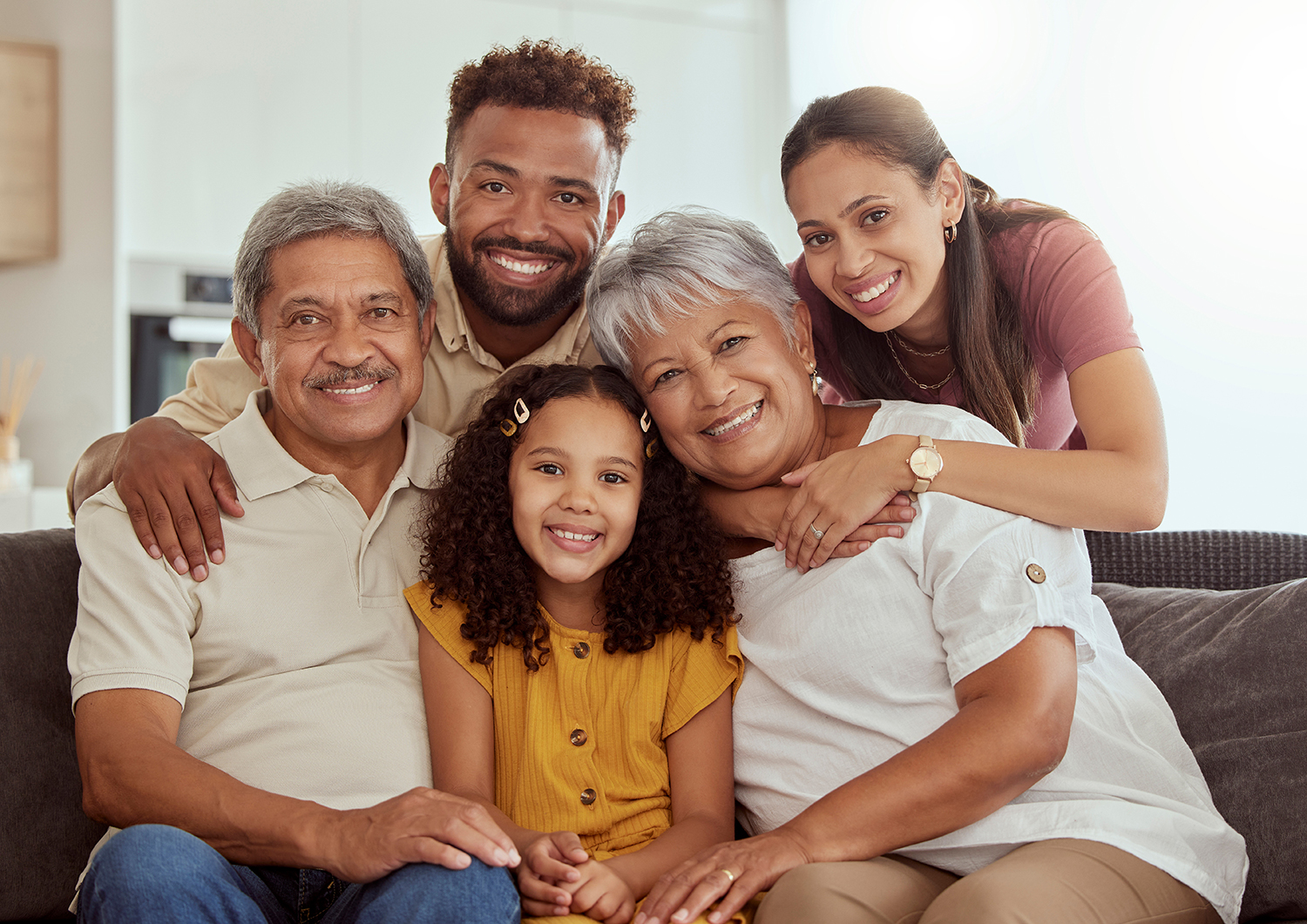 Multi-generational family sitting together on a couch, smiling